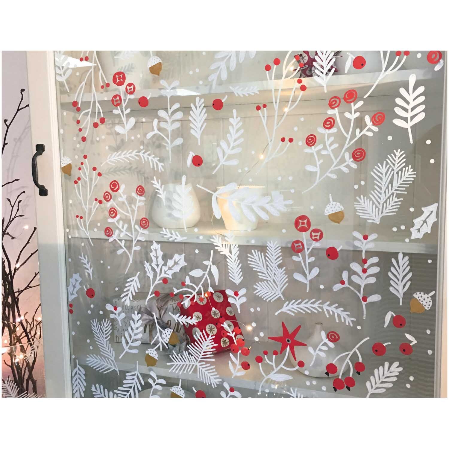 Vorlagenmappe Classical Christmas: Fenster mit festlichen roten und weißen Motiven bemalt, ideal für kreative Glasmalerei.