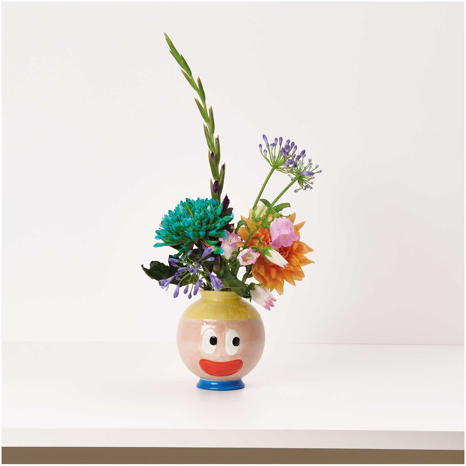 Rico Design x Redfries Keramik Vase Eye Candy mit bunten Blumen und fröhlichem Gesichtsmotiv.