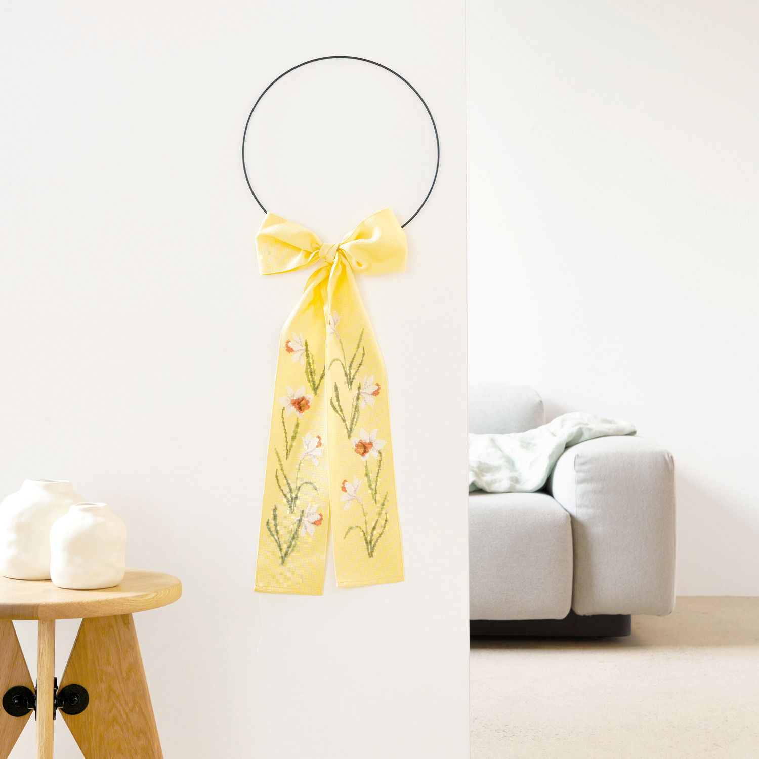 Stickpackung Schleife Narzissen zeigt eine elegante Stickerei mit Narzissenmotiv auf einem 10x170cm großen Stoff von Rico Design.