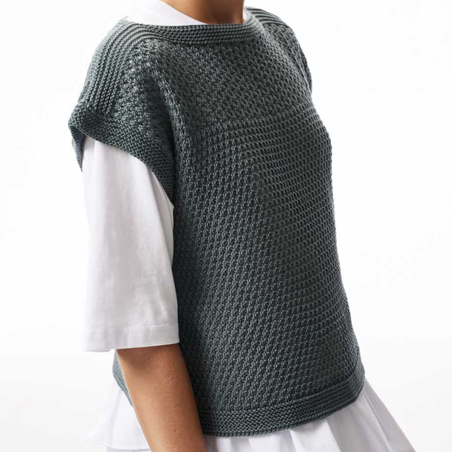 Strickanleitung Kurzarmpulli mit Lochmuster: Grauer Pulli über weißem Hemd, elegantes Design.