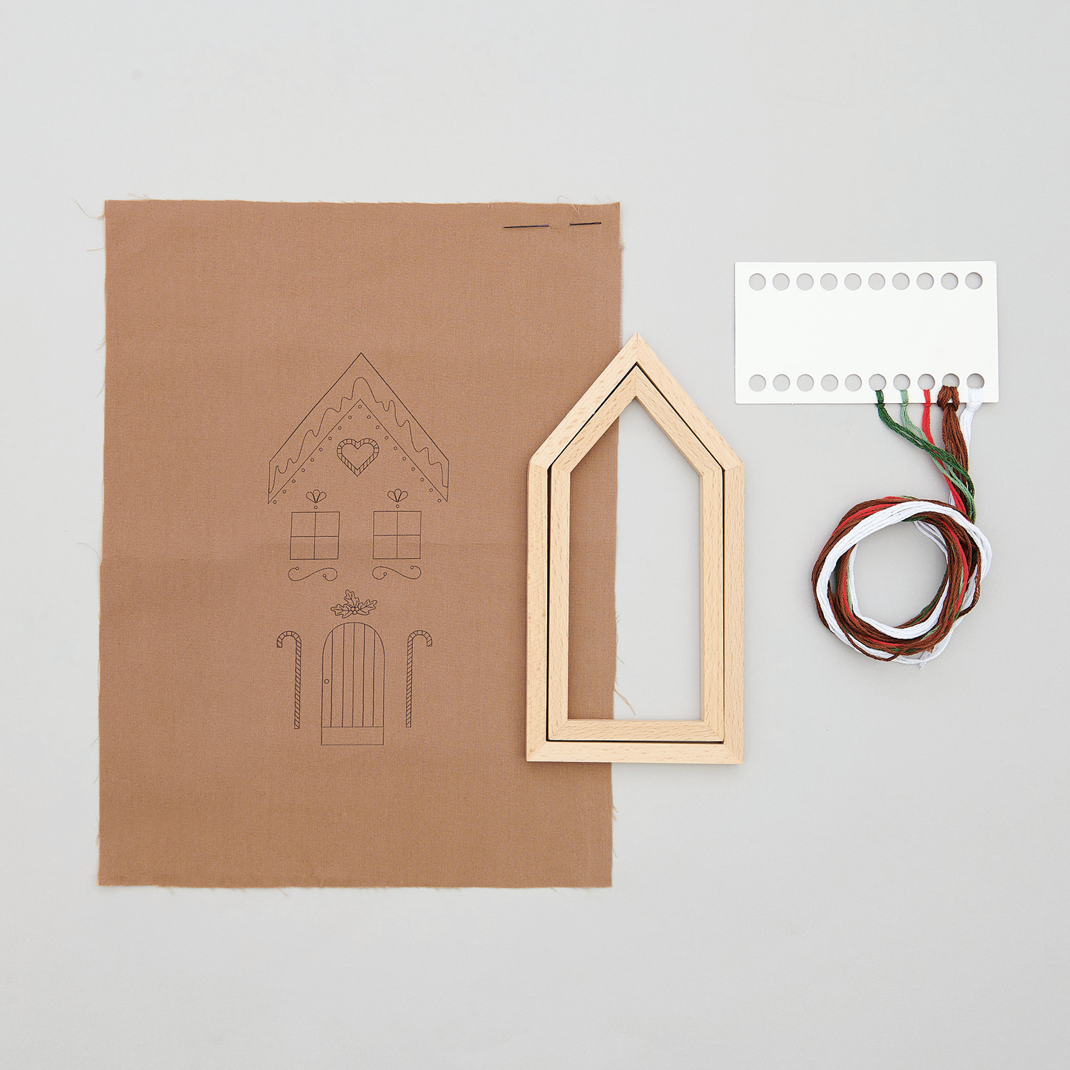 Stickpackung Lebkuchenhaus klein vorgezeichnet: Stoff mit Lebkuchenhaus-Motiv, Holzrahmen und Garn von Rico Design. Ideal für kreative Handarbeiten.