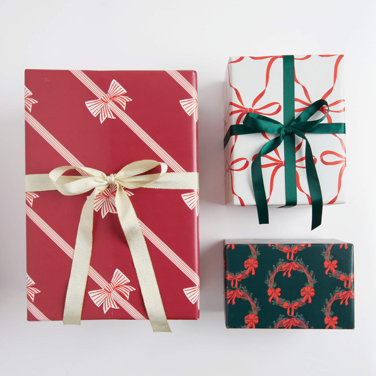 Geschenkpapier mit Schleifen und Kränzen, dekoriert mit Satinband, in festlichen Farben.
