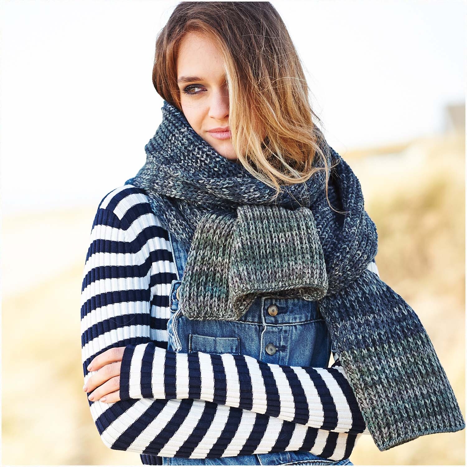 Essentials Alpaca Blend Print Chunky: Frau trägt gestreiften Pullover und blauen Schal, ideal für kühle Tage.