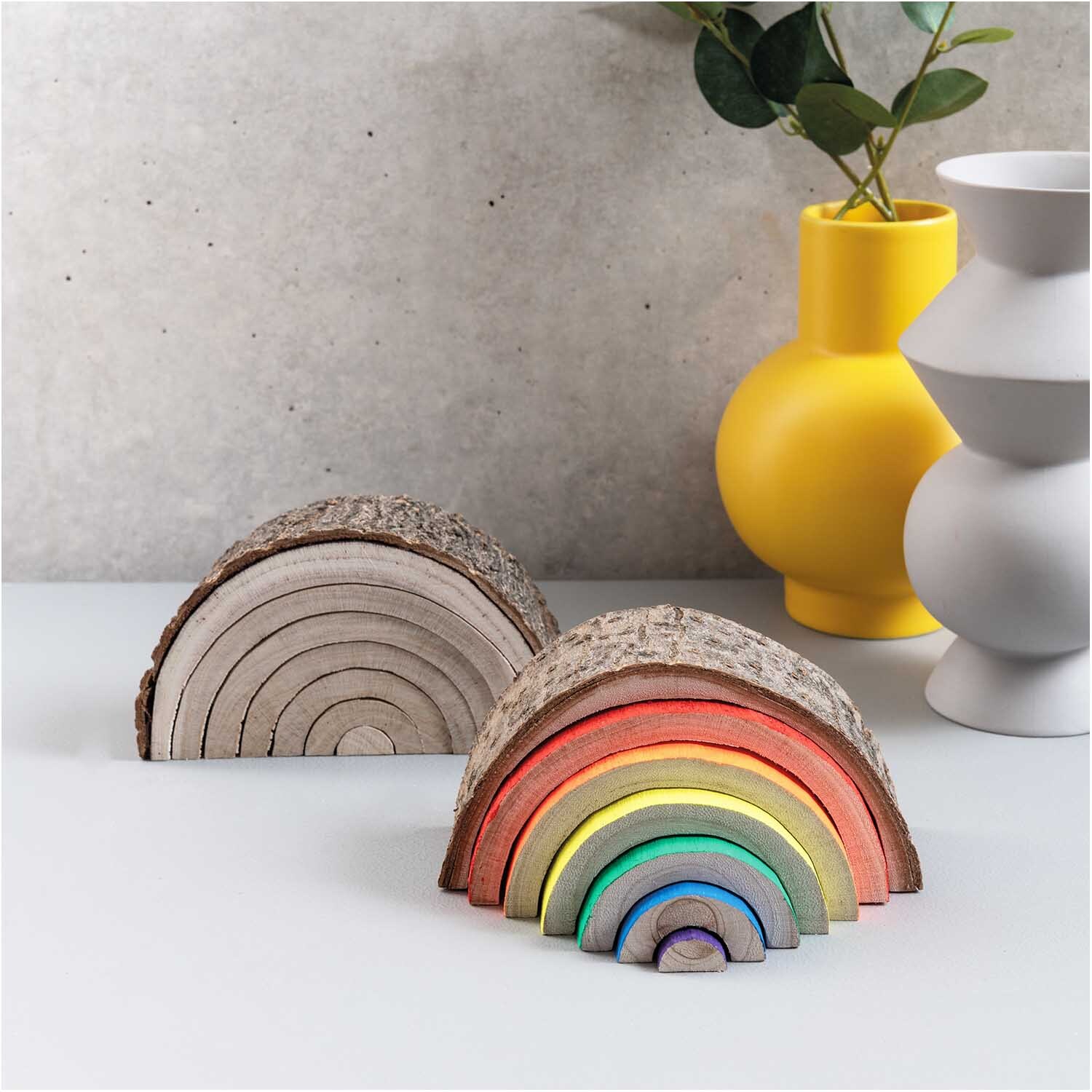 Holz-Regenbogen mit Rinde 14x8x5cm, 7-teilig, in natürlichen und bunten Farben, dekorativ vor gelber Vase.