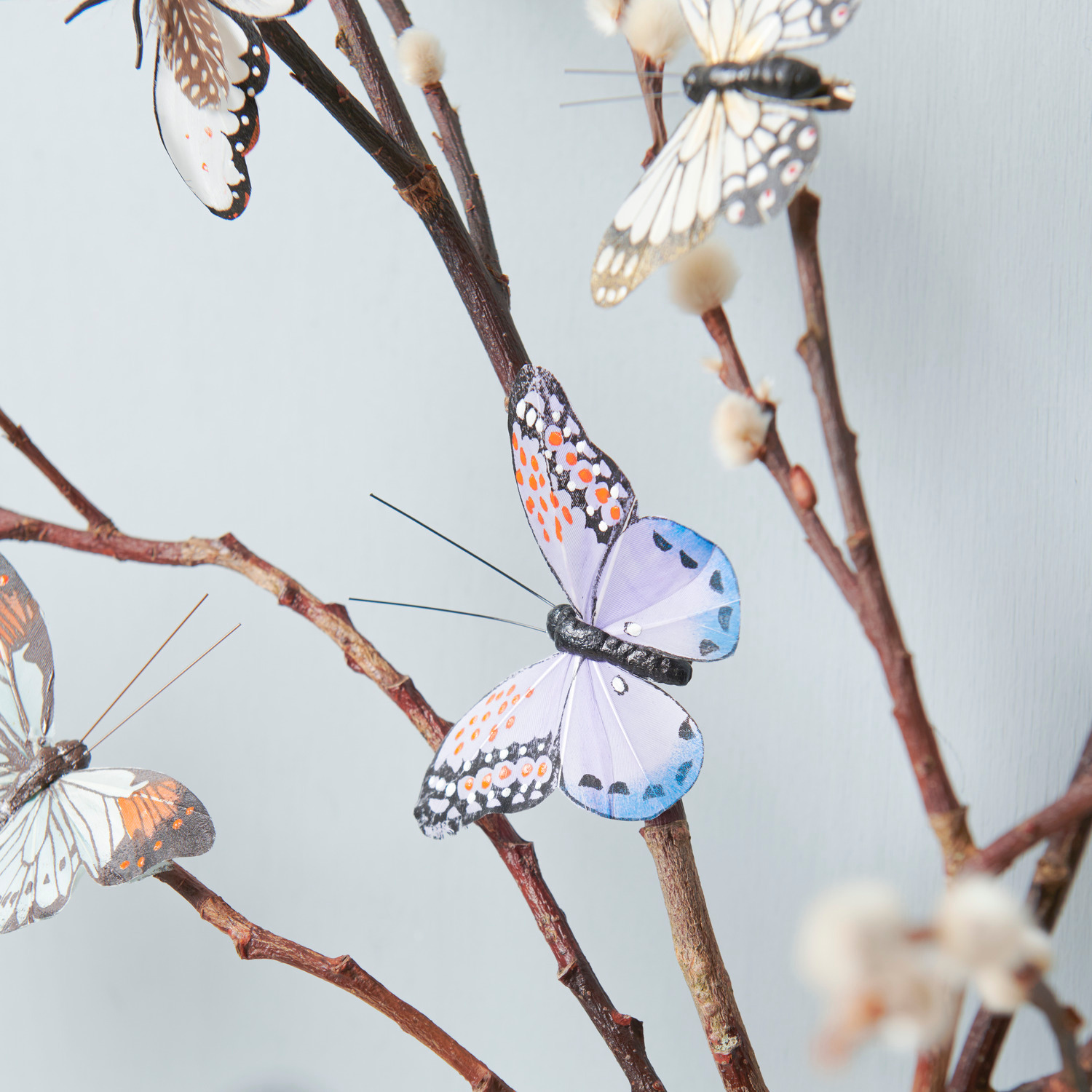 Schmetterling mit Clip Violett: Dekorativer Schmetterling auf Ast, ideal für kreative Raumgestaltung.