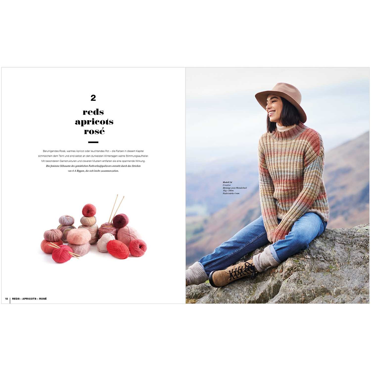 Lovewool Nr.15 Handstrickmagazin Herbst-Winter zeigt eine Frau in einem gestreiften Pullover, sitzend auf einem Felsen mit Blick auf die Berge.