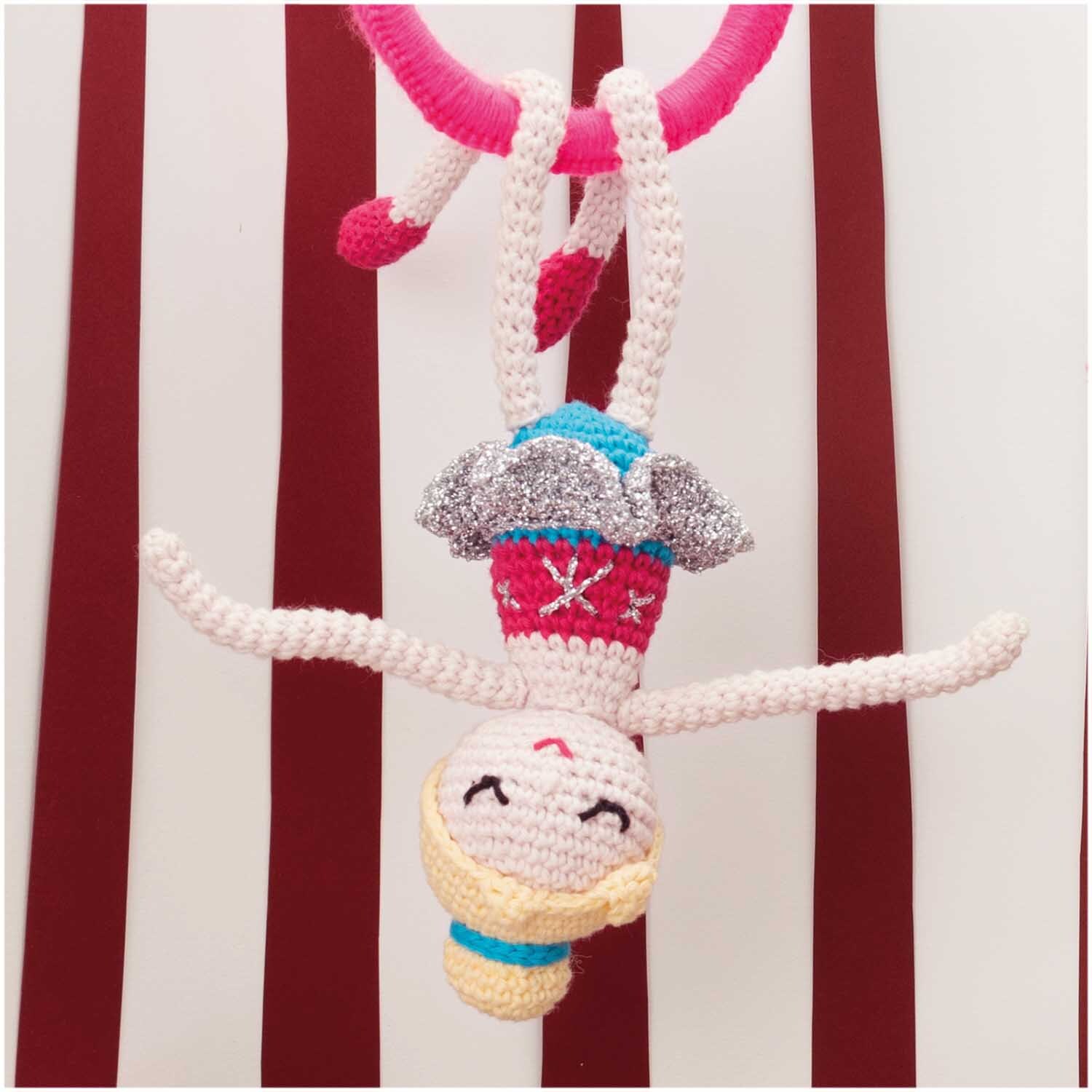 Creative Ricorumi Neon dk: Gehäkelte Figur in Neon-Pink hängt kopfüber an einem roten Seil, 25g.