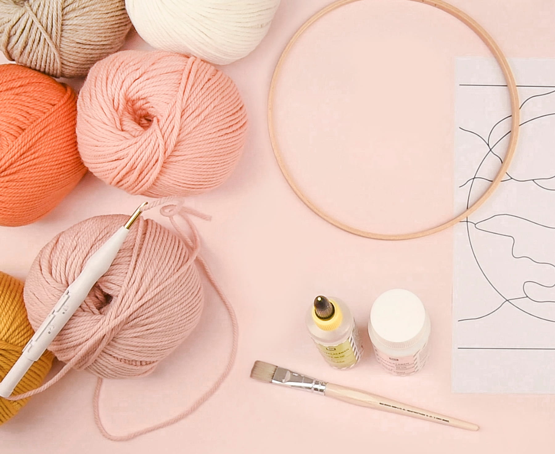 Wollknäuel, Punch Needle, Stickvorlage, Stickrahmen und weiteres Zubehör nebeneinander arrangiert 