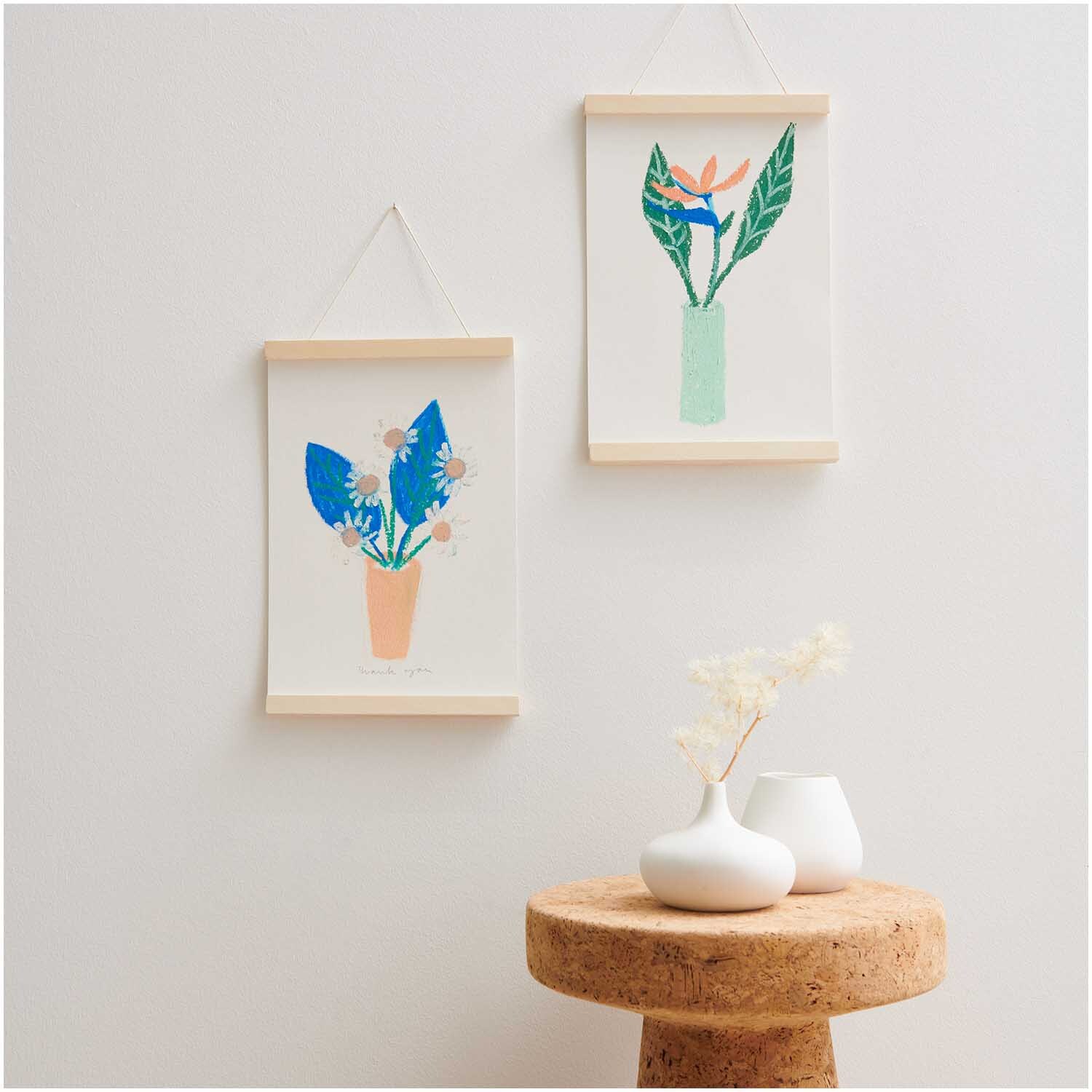 Ölpastellkreide 36 Farben: Zwei minimalistische Blumenbilder in Holzrahmen an einer weißen Wand.