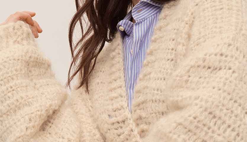 Häkelanleitung Cardigan aus Fashion Mohair Merino chunky: Frau trägt weichen, cremefarbenen Strickcardigan über gestreiftem Hemd.