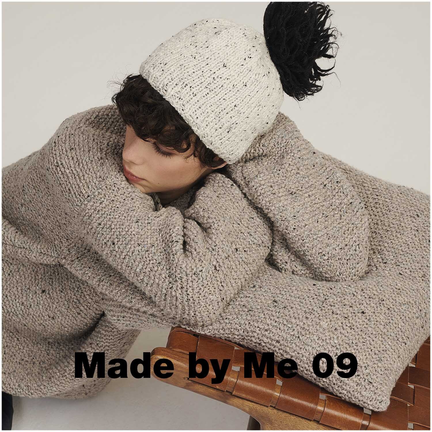 Fashion Modern Tweed aran: Person in cremefarbenem Strickpullover und Mütze von Rico Design, entspannt auf einem Stuhl.