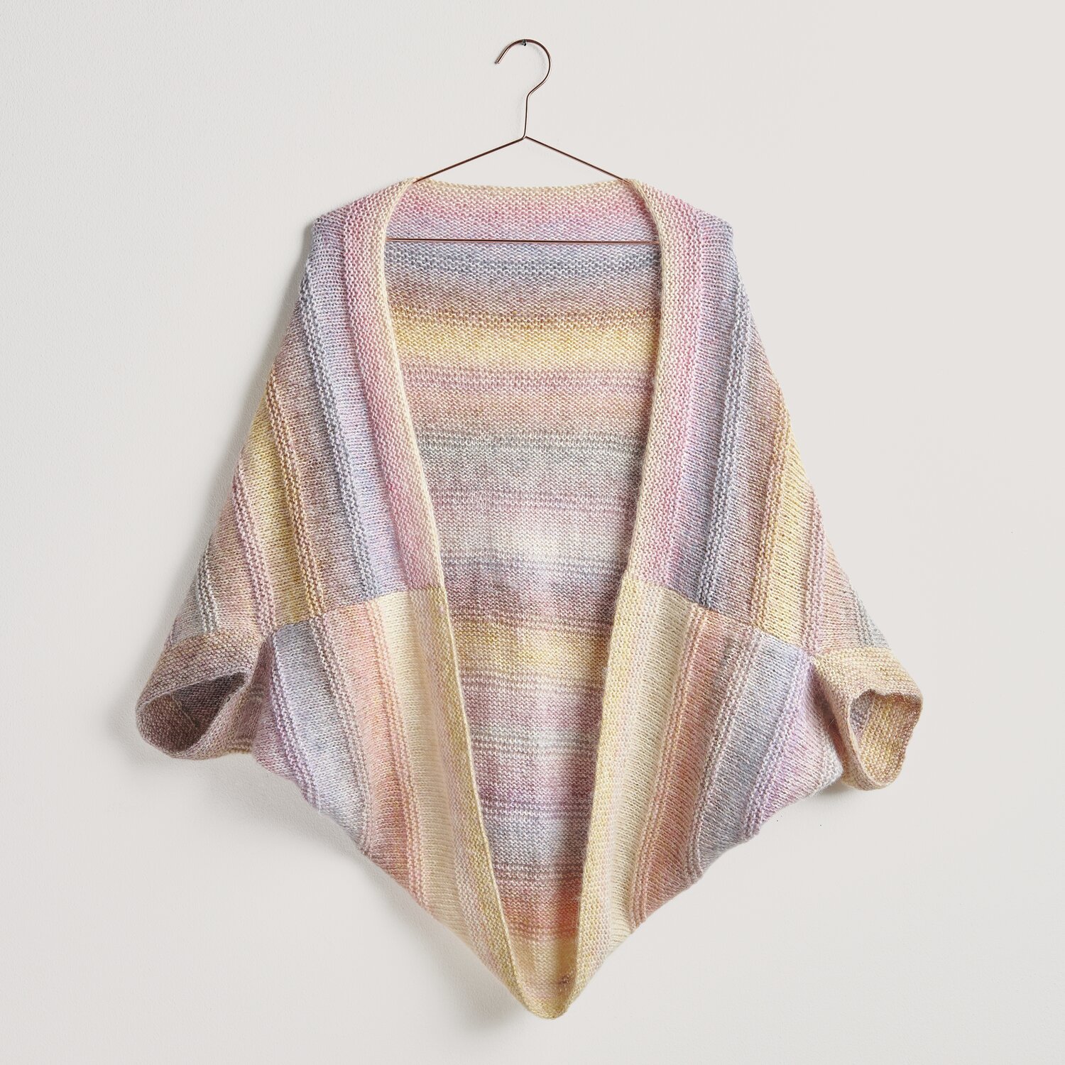 Strickset Kimono Jacke Modell 29 aus Lovewool No. 20, gestrickt in sanften Pastelltönen, hängt an einem Kleiderbügel. Ideal für Frühjahr-Sommer.