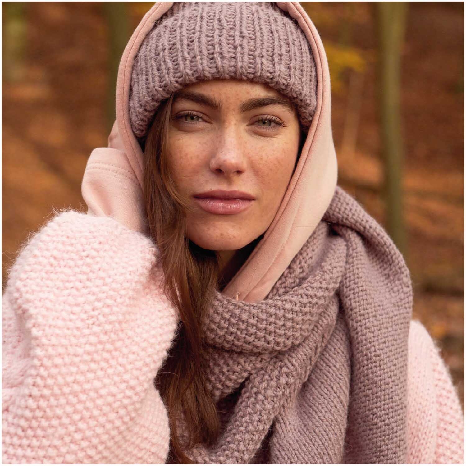 Essentials Alpaca Twist Chunky: Frau in Wald mit gestrickter Mütze, Schal und Pullover in Puder von Rico Design.