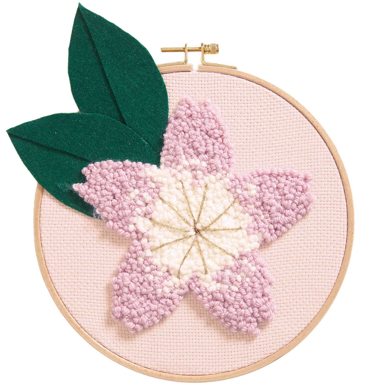 Punch Needle Packung Bild Kirschblüte zeigt eine rosa Blume mit grünen Blättern auf Stoffrahmen.