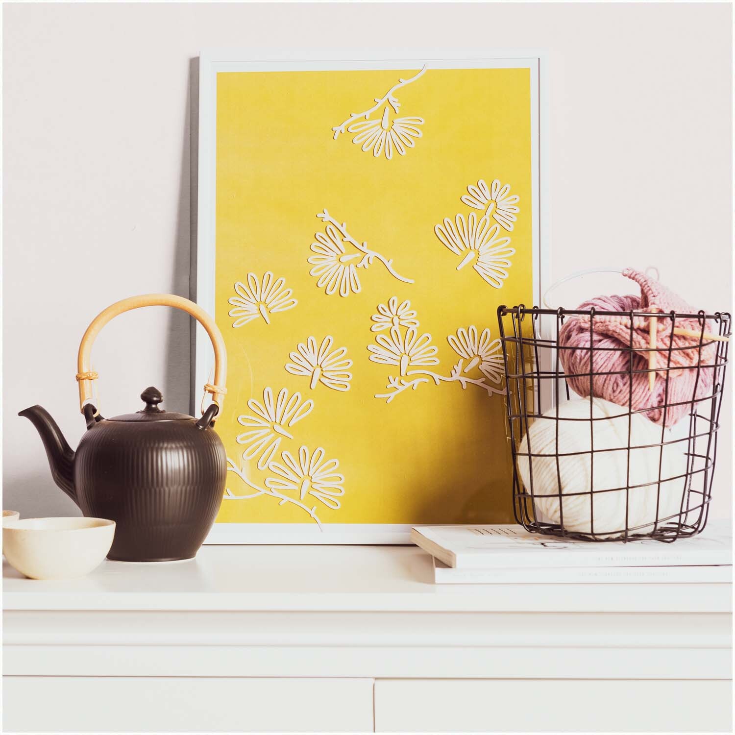 Kreidestifte Flüssigkreide Set Natur 3mm 6 Farben: Ein gelbes Poster mit weißen Blumen, daneben ein schwarzer Teekessel und ein Korb mit Garn.