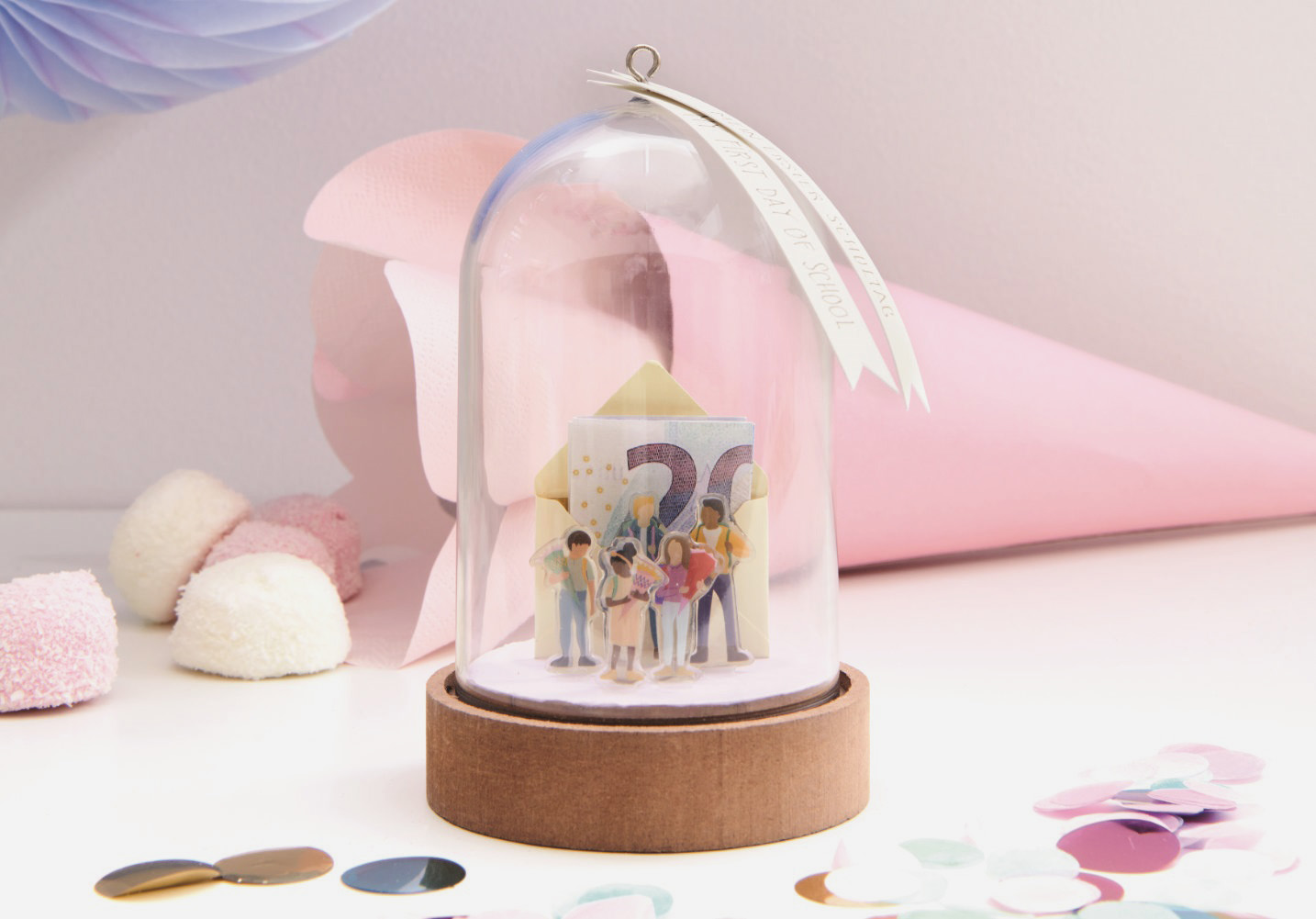 Dekohaube befüllt mit Mini-Umschlag und 20-Euro-Schein, sowie mehreren Mini-Figuren.