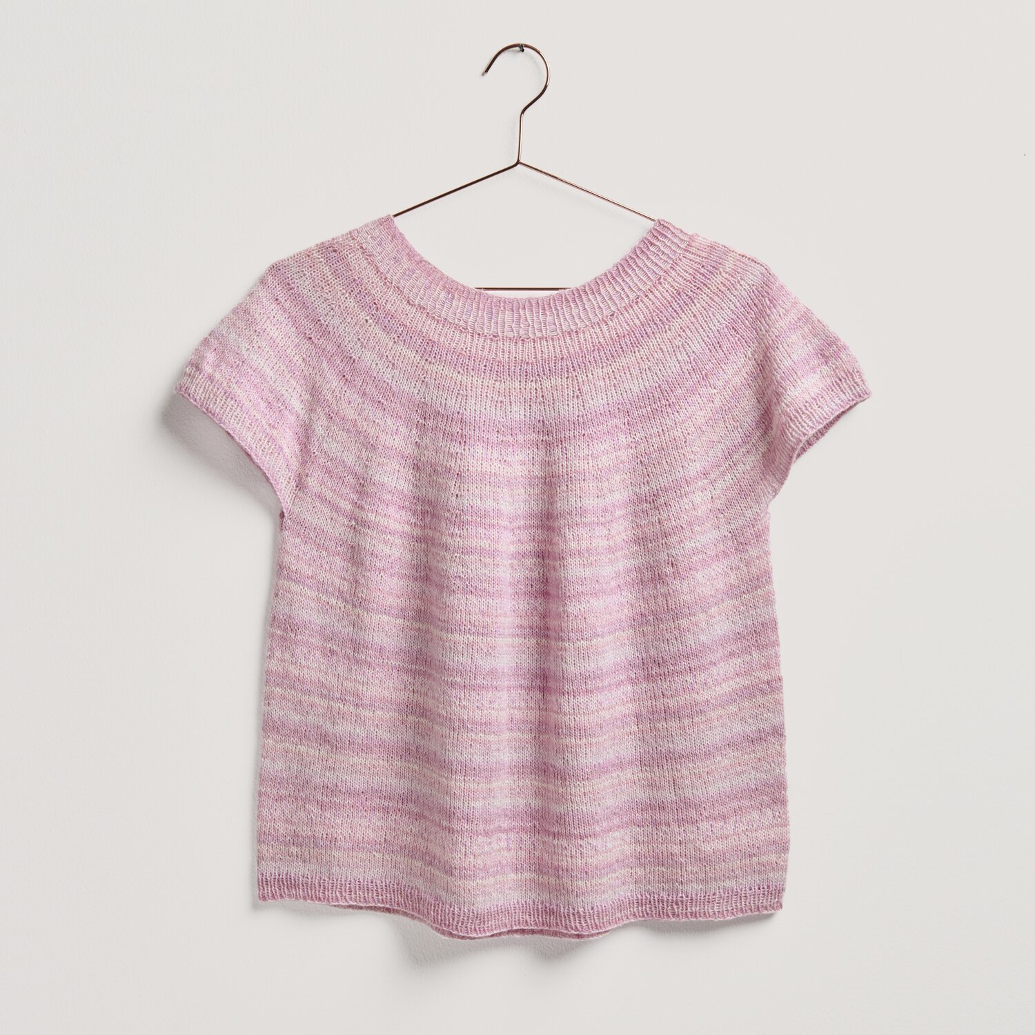 Strickset Shirt Modell 25 in Rosa, aus Lovewool No. 20, präsentiert auf einem Kleiderbügel.