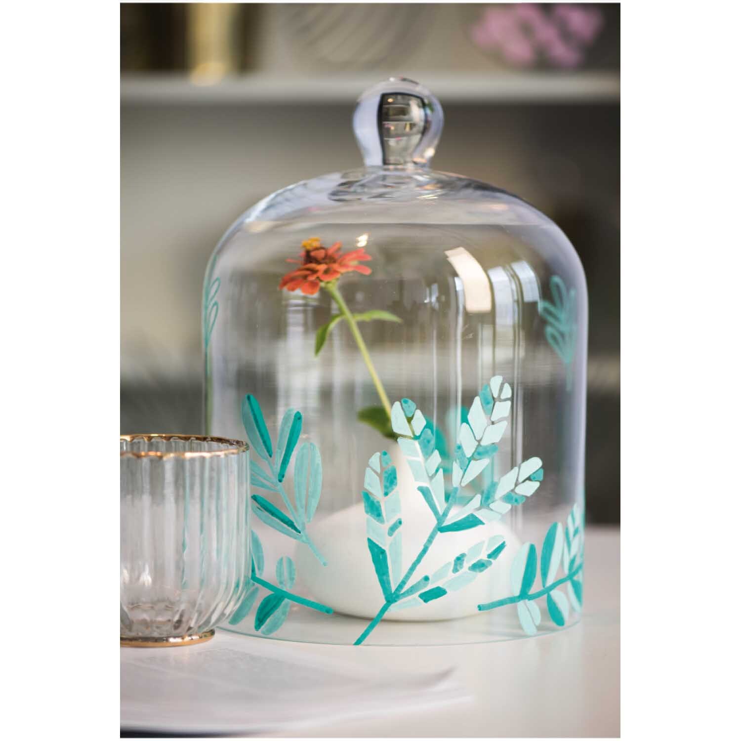Kreidestifte Flüssigkreide Set Pastell: Eine Glasglocke mit floralen Mustern, dekoriert mit pastellfarbenen Kreidestiften von Rico Design.