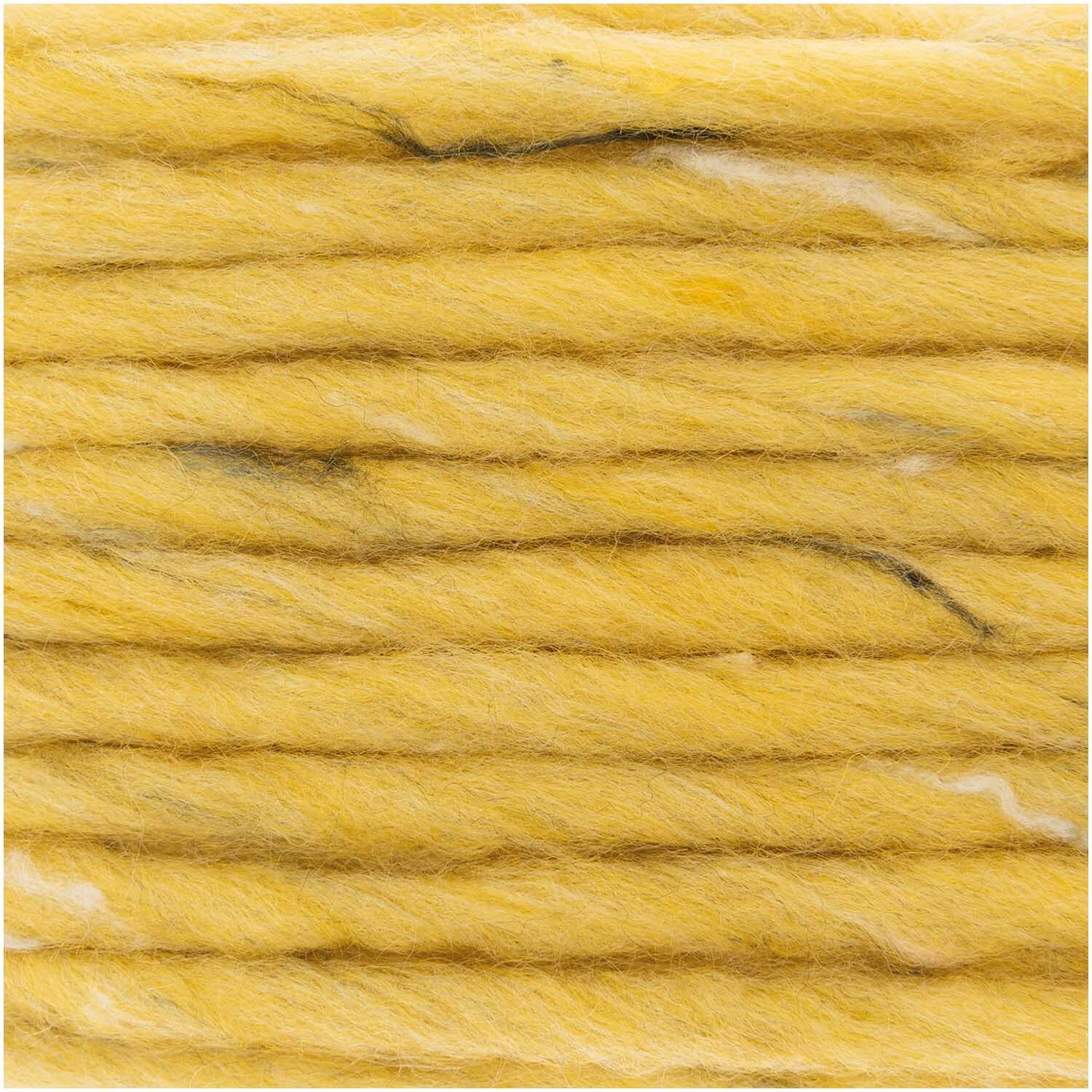 Essentials Super Tweed super chunky: Nahaufnahme von gelbem Garn mit Tweed-Effekt, 100g 90m, von Rico Design. Ideal für Strickprojekte.