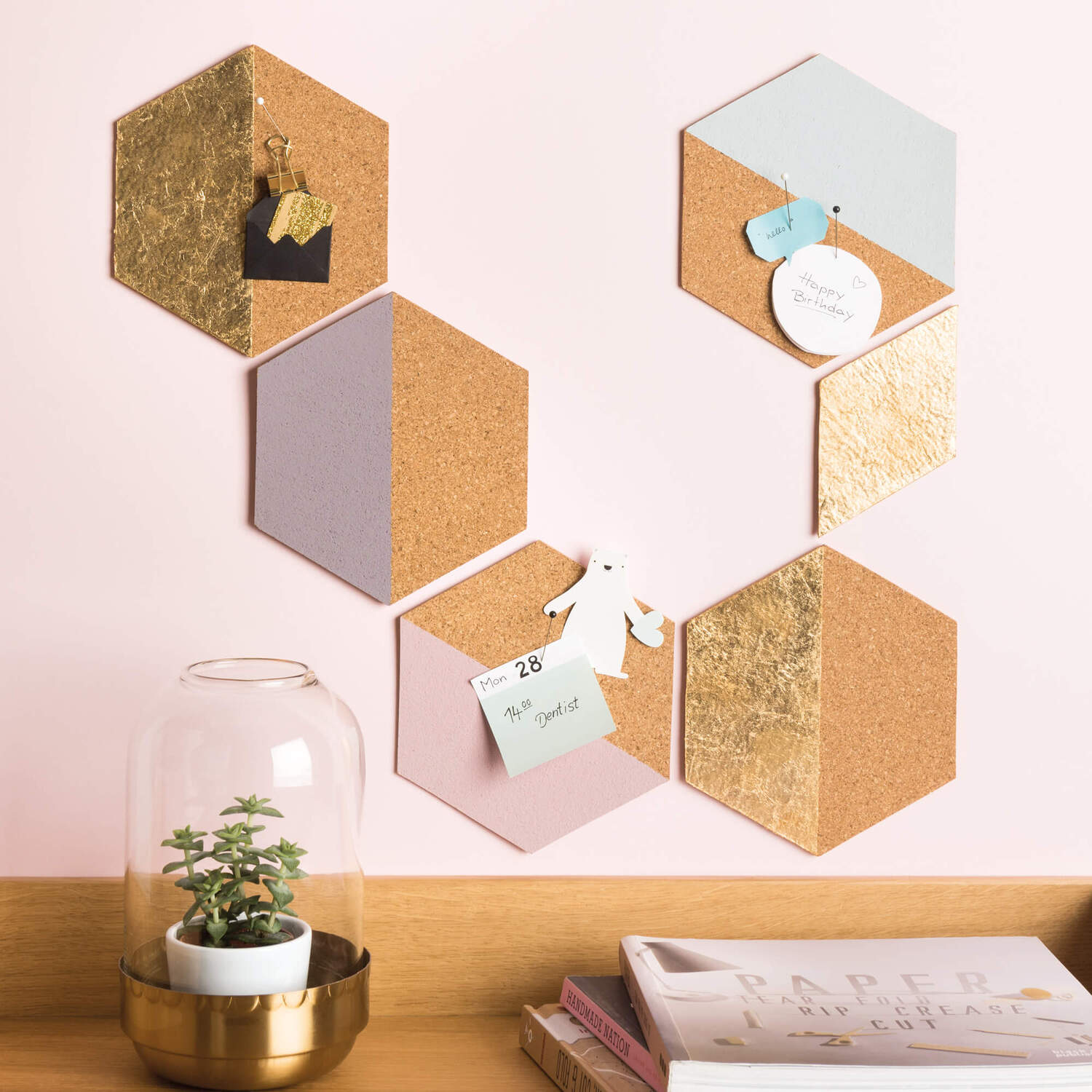 Bastelanleitung Pinnwand aus Kork: Sechseckige Korkplatten an der Wand, dekoriert mit Notizen und Pflanzen.