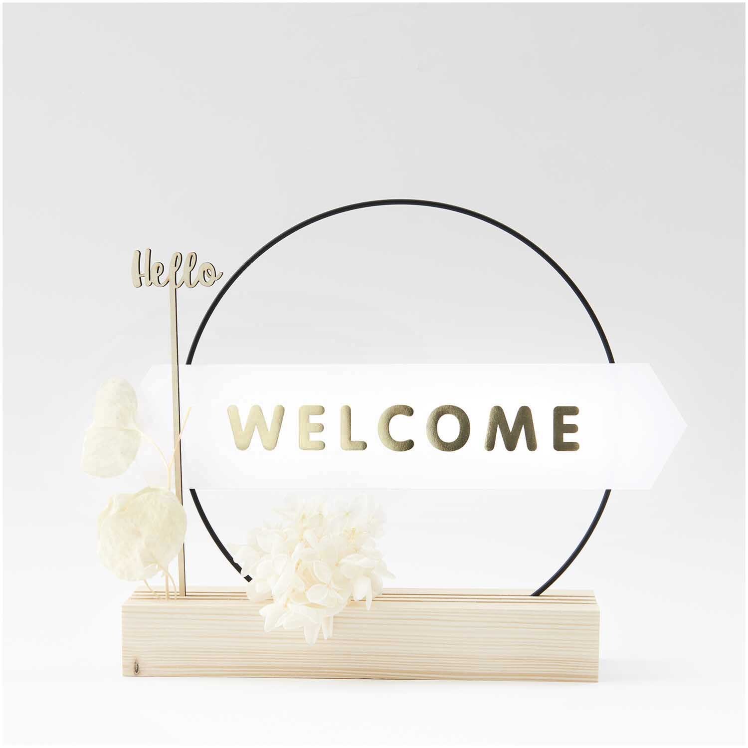 Paper Poetry Papierstreifen dekorieren einen Holzständer mit "Welcome"-Schriftzug und Blumen.