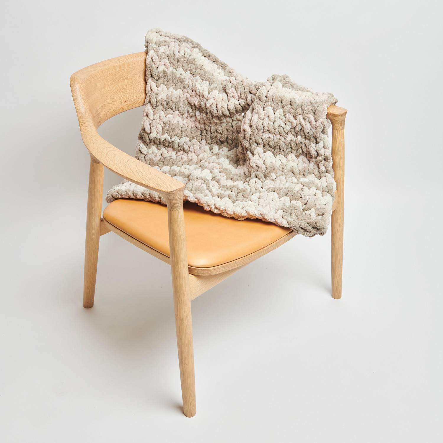 Chenillove Super Big Print: Weiche, naturfarbene Decke von Rico Design auf einem modernen Holzstuhl.
