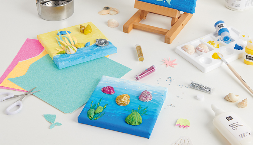 Bastelanleitung Unterwasserwelt auf Leinwand: Kreative Materialien und Werkzeuge für ein maritimes Kunstprojekt auf einem Tisch arrangiert.