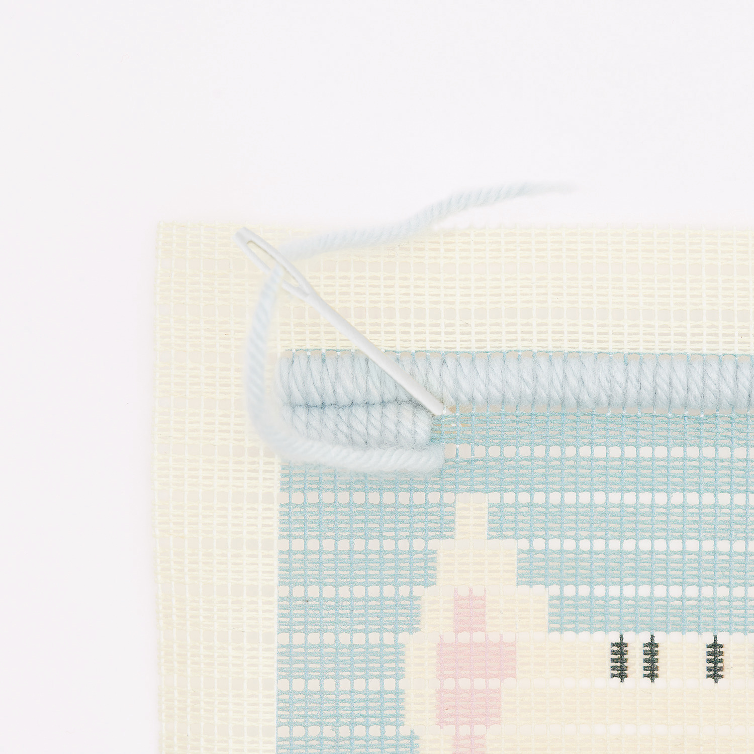 Longstitch Stickpackung Katze zeigt eine begonnene Stickarbeit mit Nadel und blauen Fäden von Rico Design.