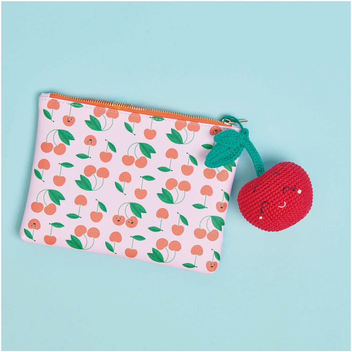 Creative Ricorumi dk: Eine Tasche mit Kirschmuster und gehäkeltem Kirschanhänger auf blauem Hintergrund.