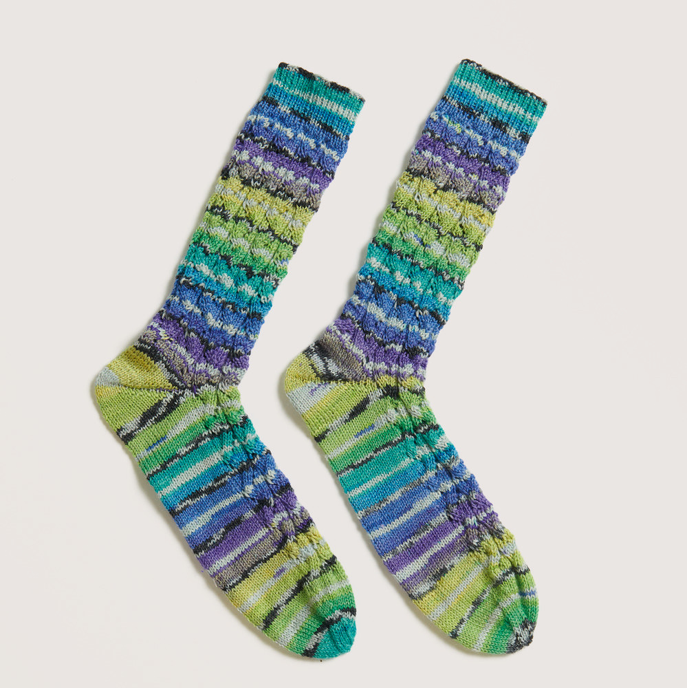 Bunte Socken auf grauem Hintergrund – zum Strickset