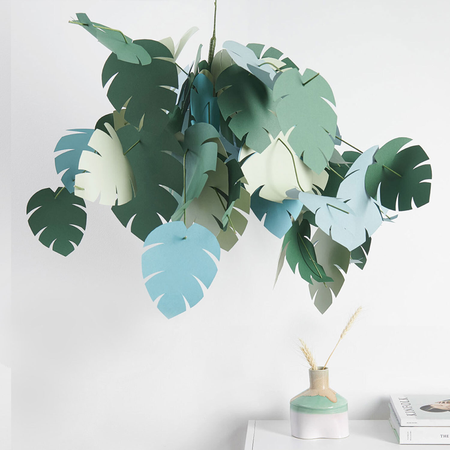Bastelanleitung Papierfontäne mit Palmenblättern: Dekorative Papierblätter in Grün- und Blautönen hängen kunstvoll von der Decke.