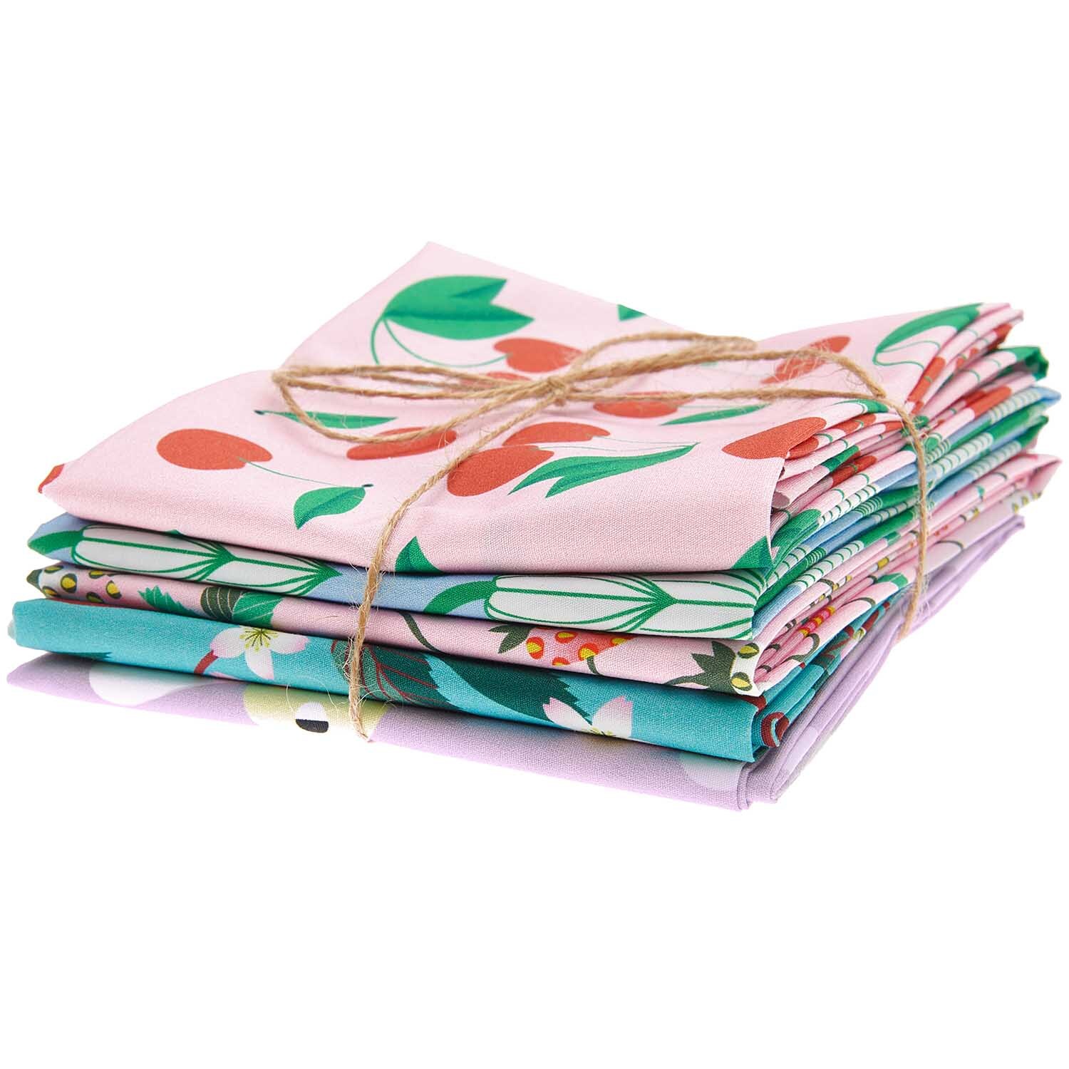 Stoffpaket mit 5 Stoffen, gebunden mit Juteschnur, zeigt bunte Muster von Früchten und Blumen.