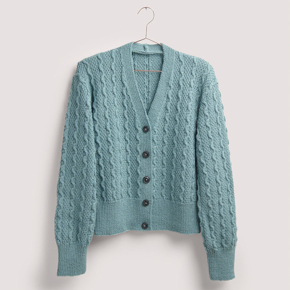 Blaue Strickjacke auf grauem Hintergrund – zum Strickset