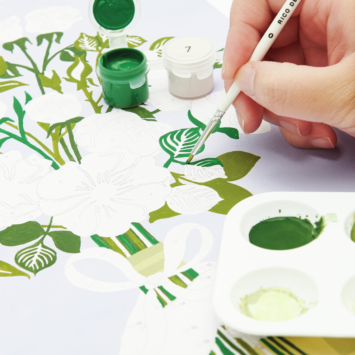 Malen nach Zahlen Rosen Bouqet: Hand malt grüne Blätter auf Leinwand mit Farbpalette und Pinsel.