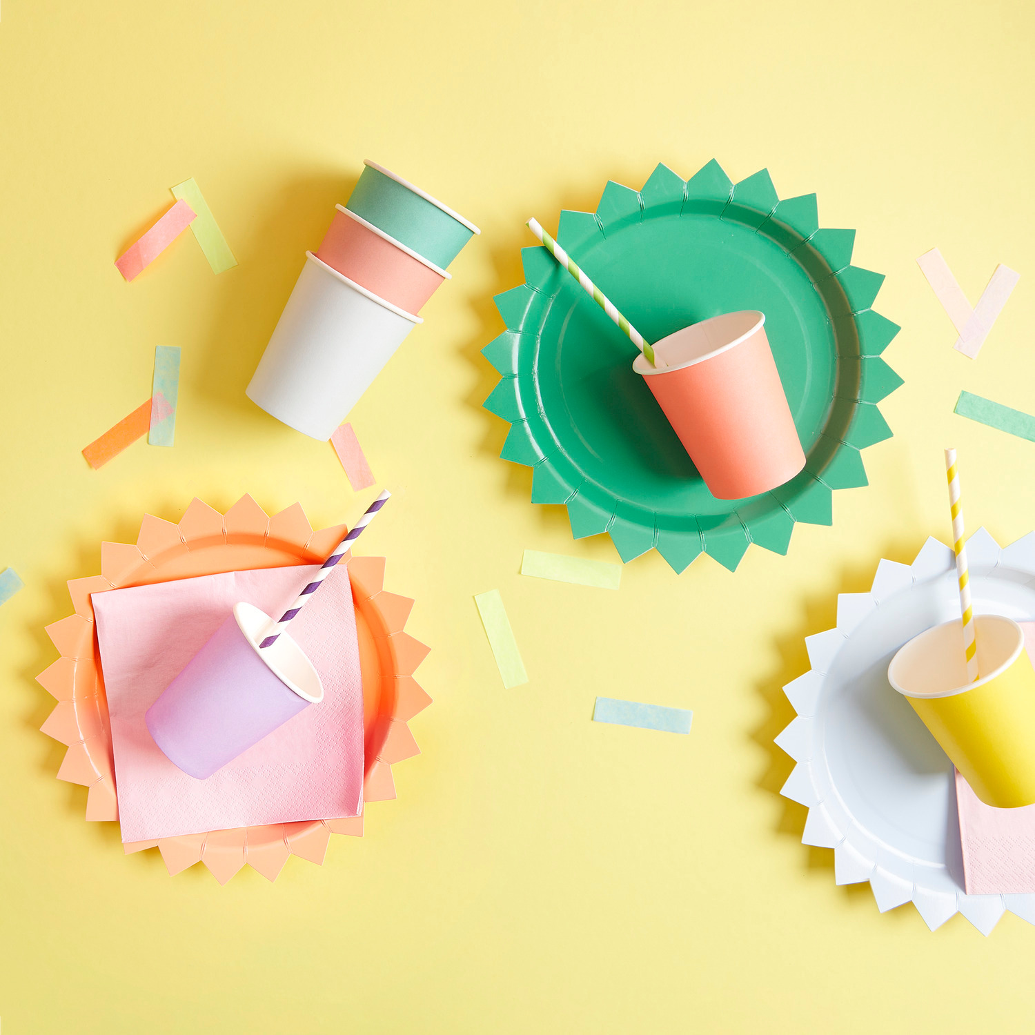 Pappbecher bunt 250ml 8 Stück: Bunte Pappbecher und Pappteller von Rico Design auf gelbem Hintergrund.