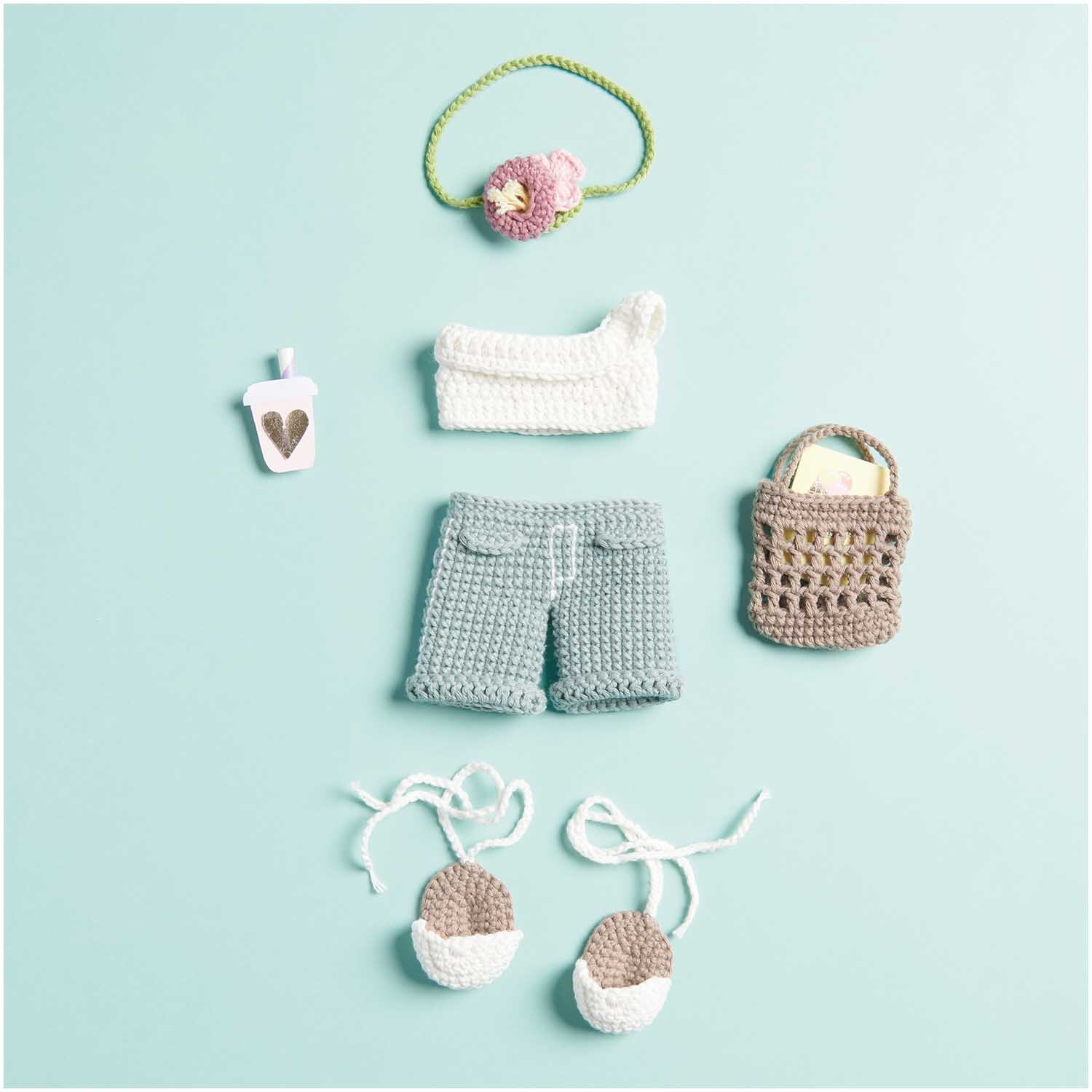 Ricorumi Dollies City Girls: Gehäkelte Kleidung und Accessoires auf hellblauem Hintergrund, inklusive Tasche und Schuhe.