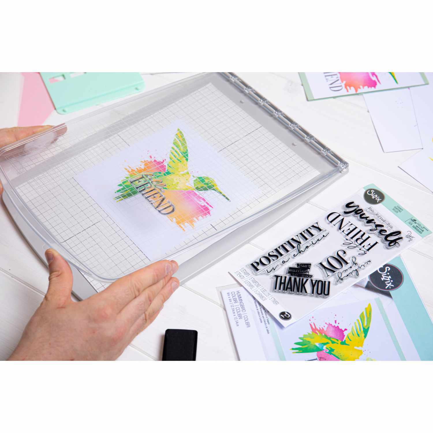 Stencil & Stamp Tool von Sizzix: Kreatives Werkzeug mit buntem Kolibri-Design und inspirierenden Stempeln.