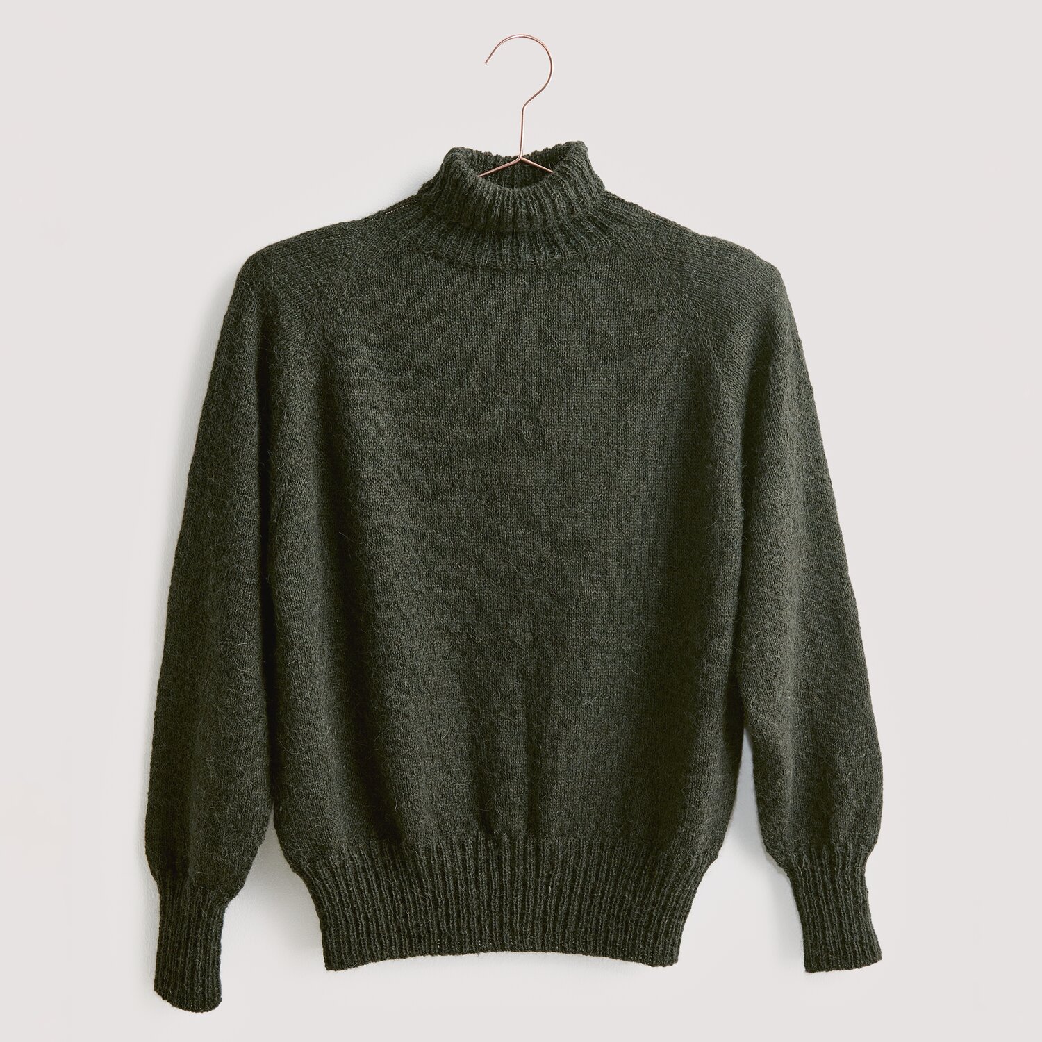 Strickset Pullover Modell 15 aus Luxury Knits. Dunkelgrauer Rollkragenpullover aus Premium Natural Fibres, hängend an einem Kleiderbügel.