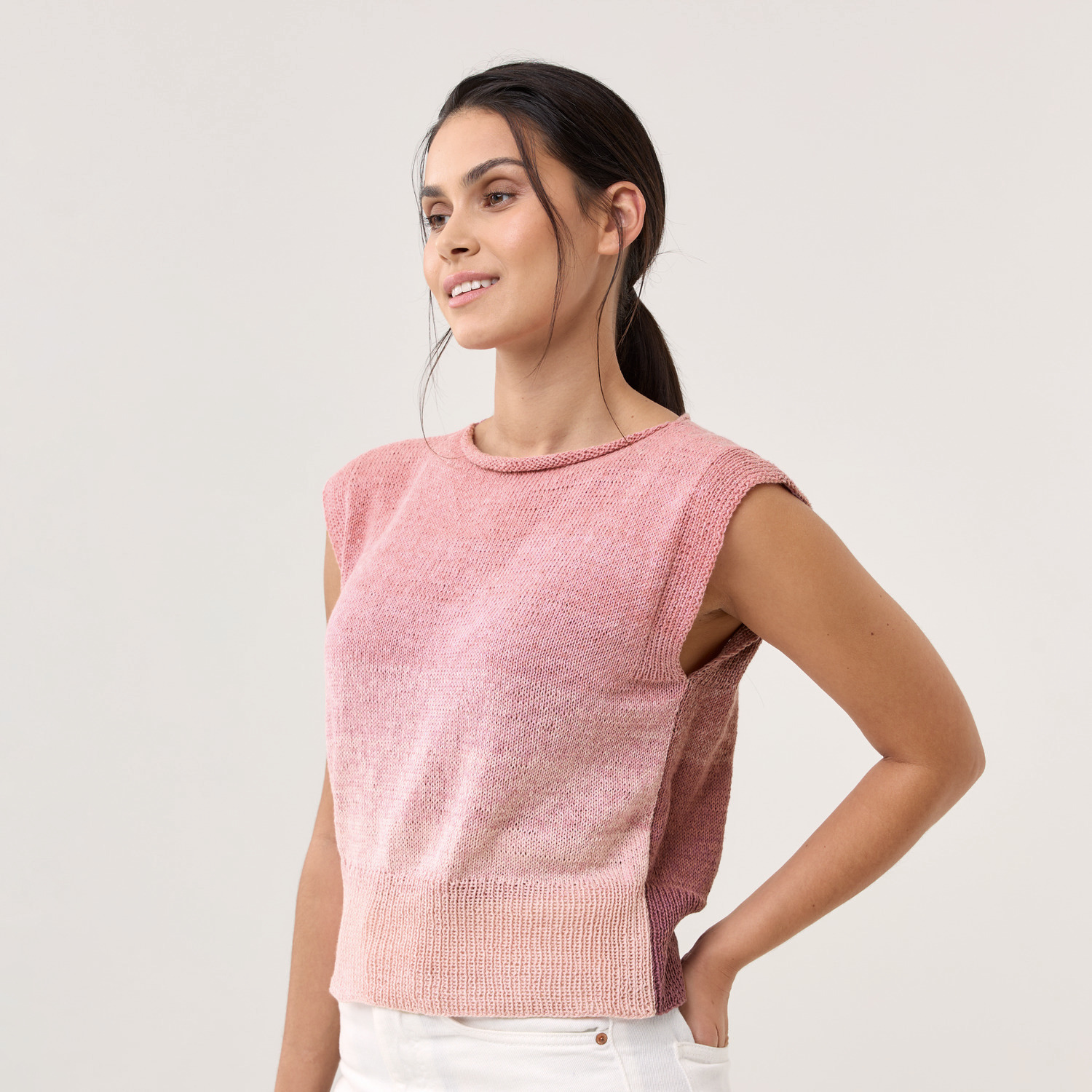 Strickset Shirt Modell 11: Frau trägt ein rosa Strickshirt mit kurzen Ärmeln, lässig und modern.