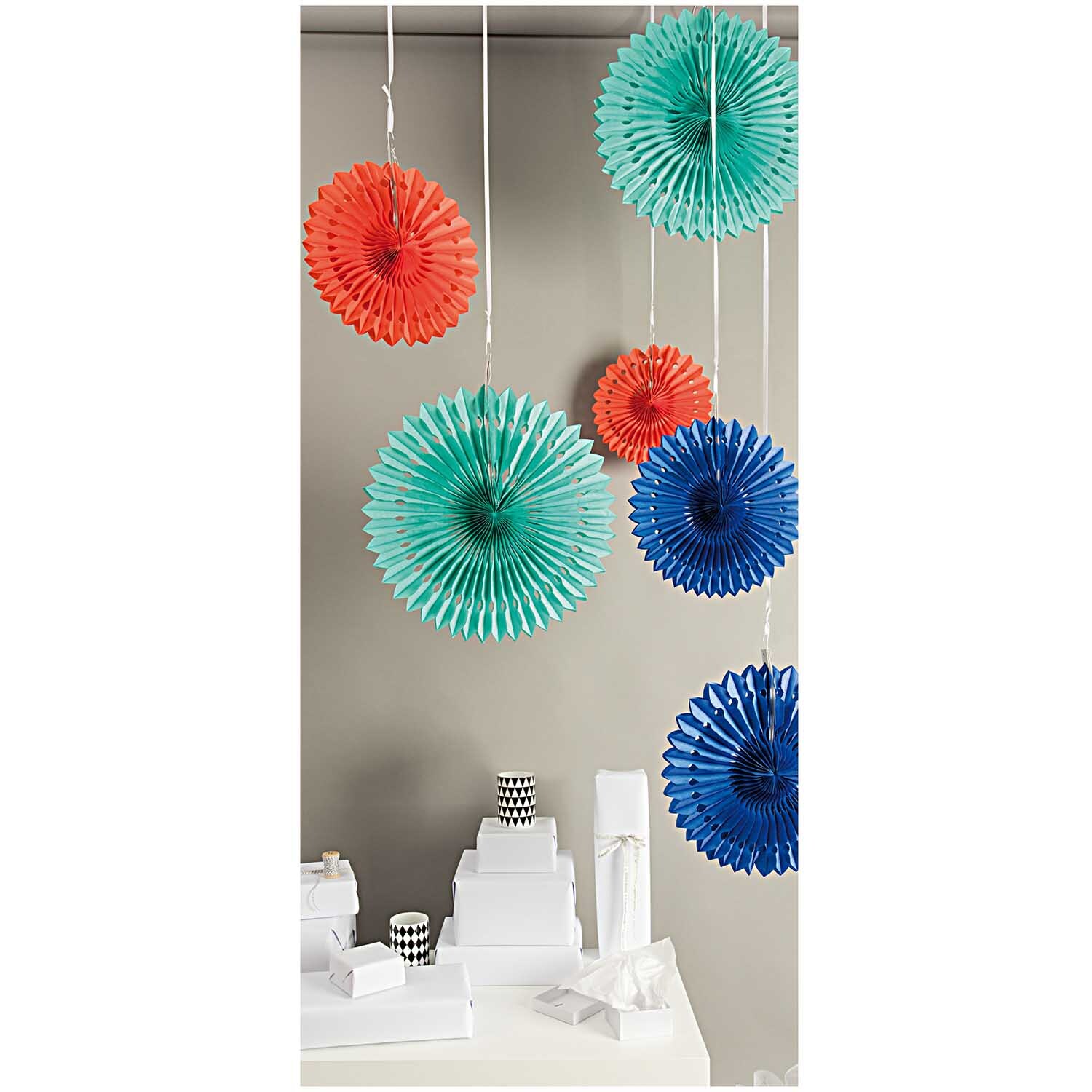 Wabenpapier Blumen mehrfarbig 3 Stück von Rico Design: Bunte Papierblumen hängen dekorativ von der Decke.