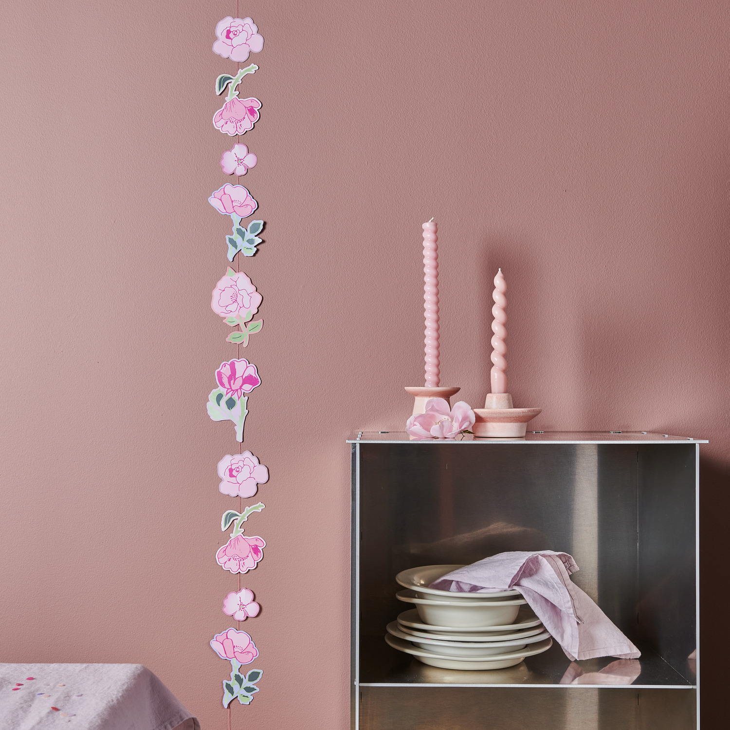 Paper Poetry Genähte Girlande Rosen: Rosa Girlande mit Blumenmotiven von Rico Design, dekorativ an einer Wand hängend.