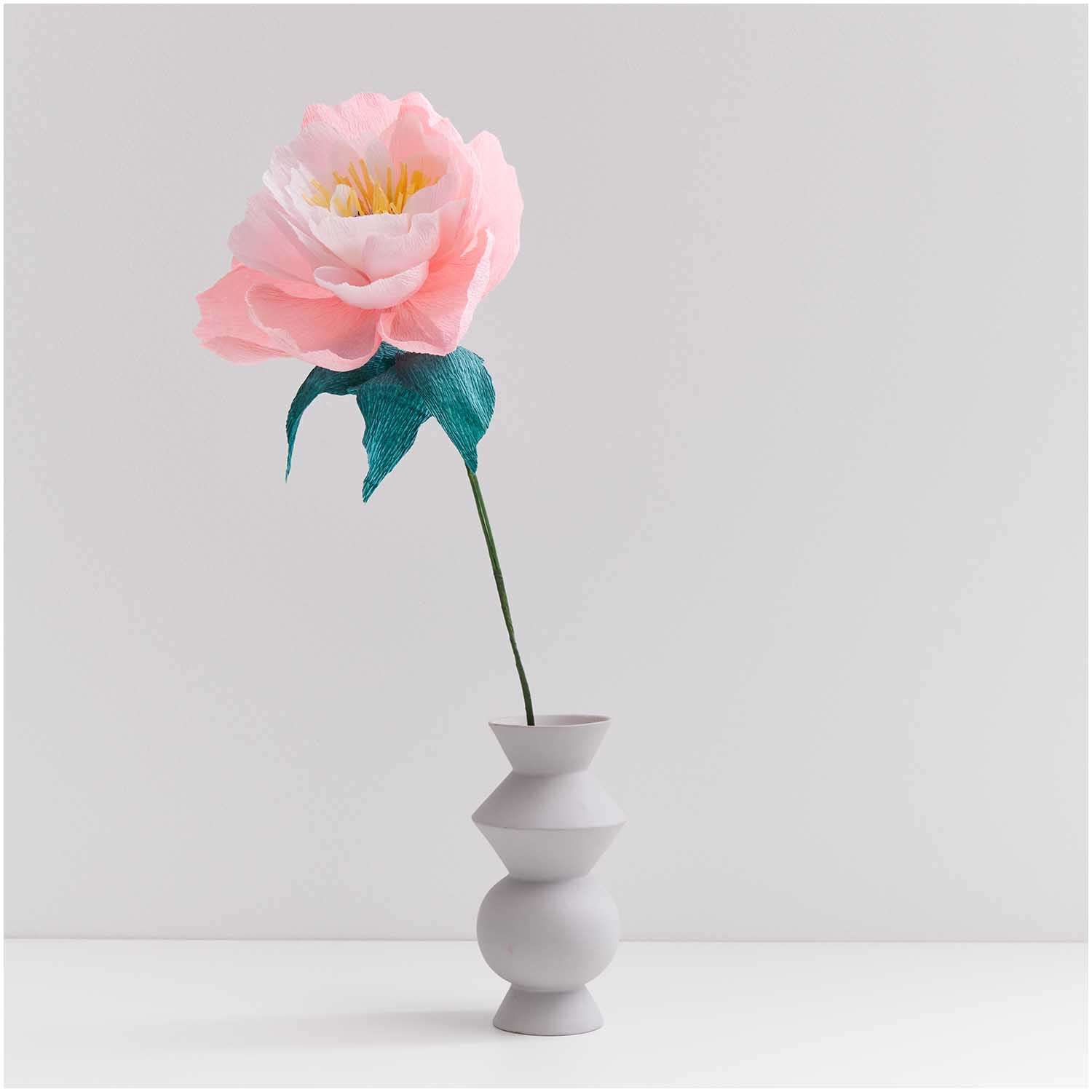 Papierdraht 1,8mm 1m 10 Stück: Eine rosa Papierblume in einer grauen Vase, dekorativ arrangiert.