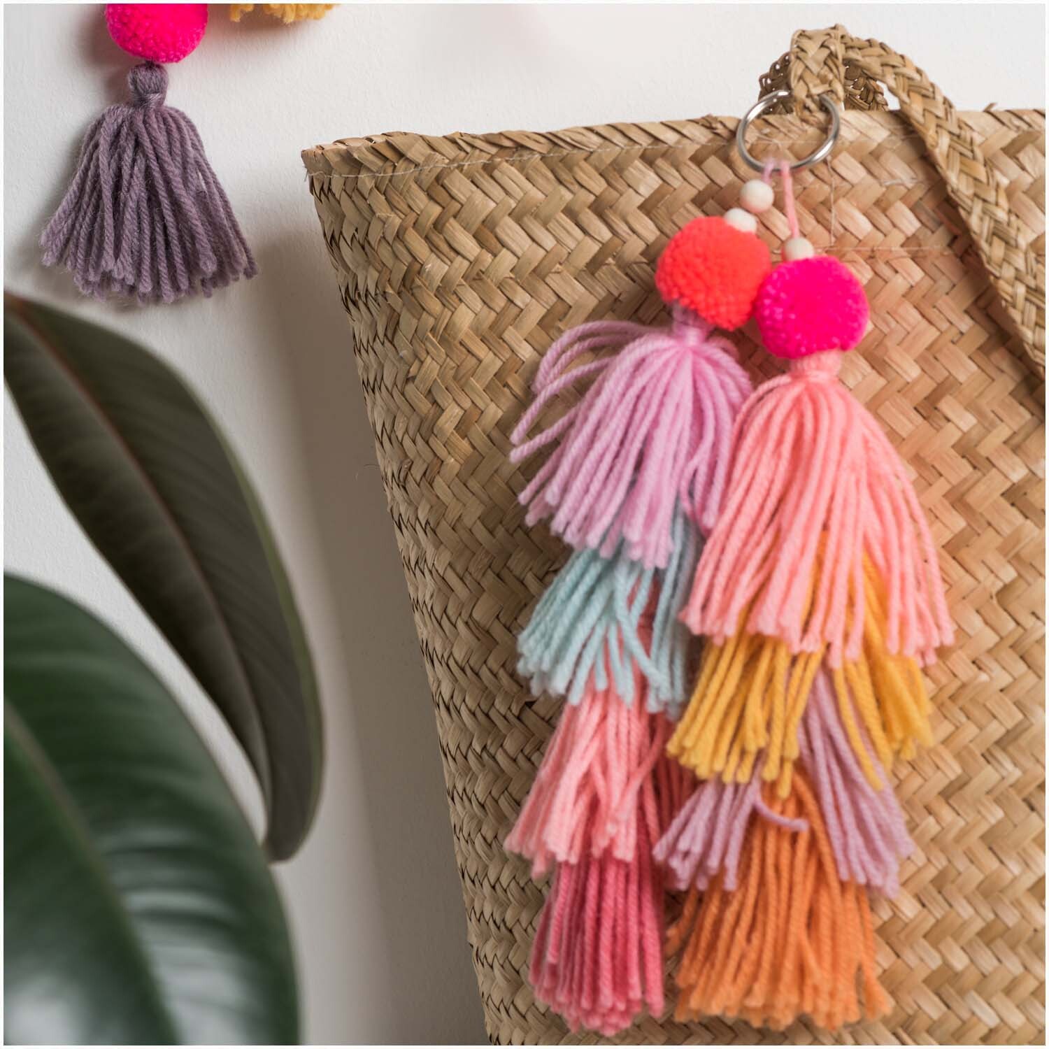 Quasten 9cm 4 Stück: Bunte Quasten in Pastellfarben an einem geflochtenen Korb, ideal als Dekoration.