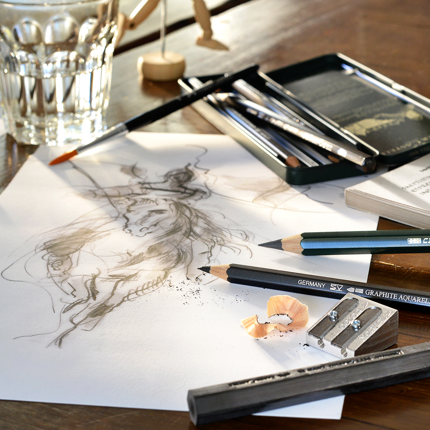 Pitt Graphite Set: Künstlerbedarf von Faber Castell, 11-teilig, mit Skizze und Zubehör auf Holztisch. Ideal für Zeichnungen und Skizzen.