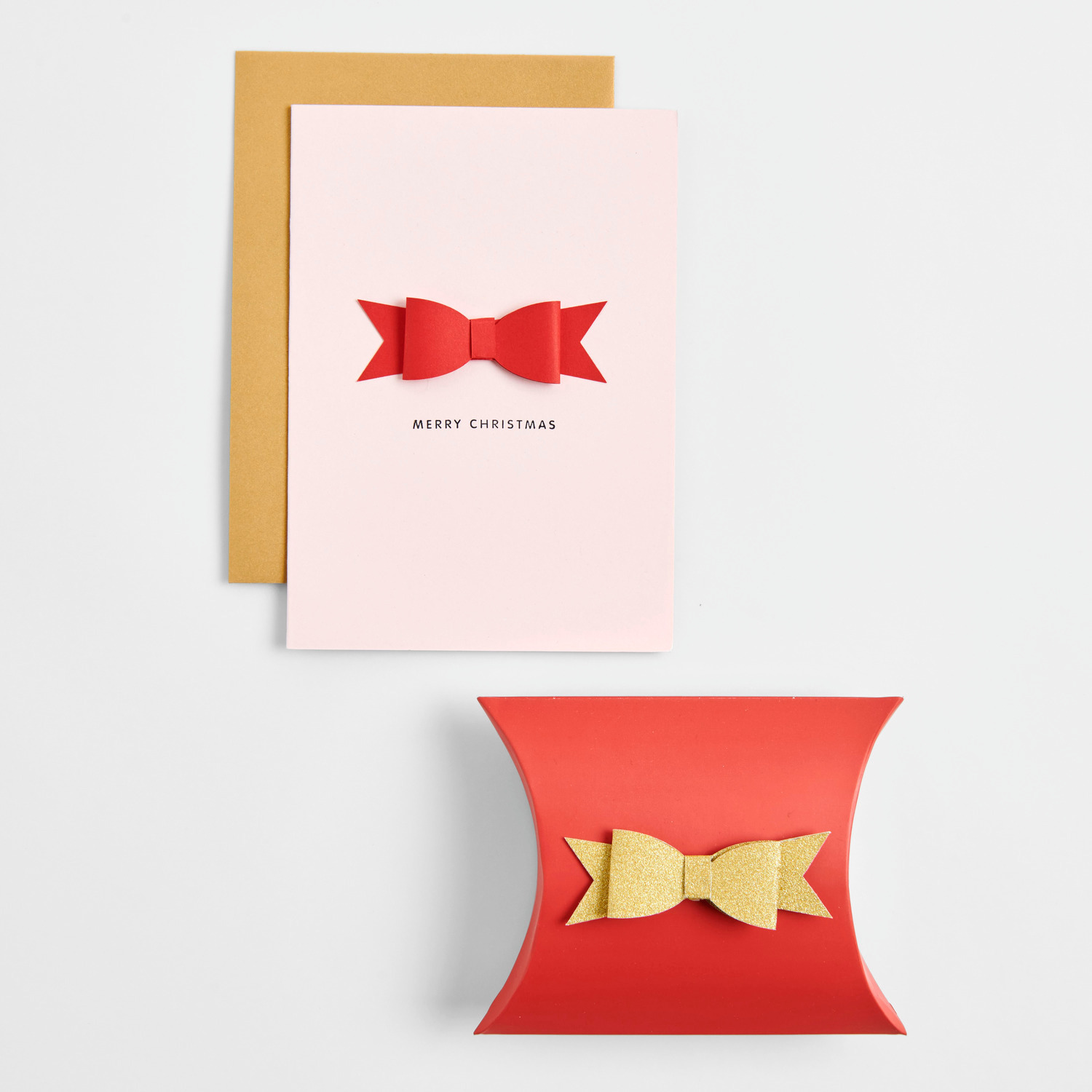 Paper Poetry 3D Sticker Schleifen Rot auf einer Weihnachtskarte und Geschenkbox. Elegante Dekoration in Rot und Gold für festliche Anlässe.