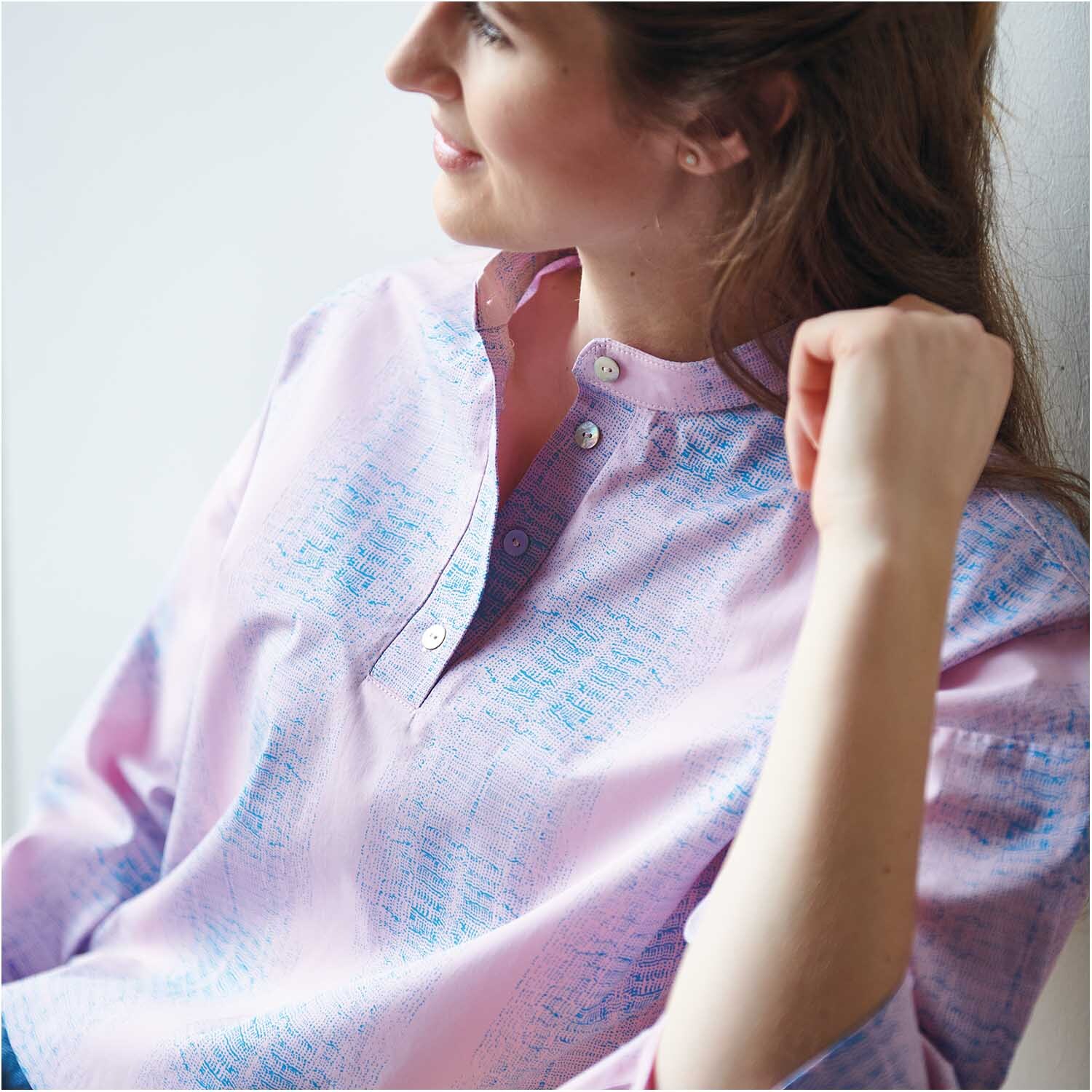 Stoffabschnitt Druckstoff Muster bonbonrosa-azur von Rico Design, zeigt eine Frau in pastellfarbener Bluse mit dezentem Muster, ideal für kreative Nähprojekte.
