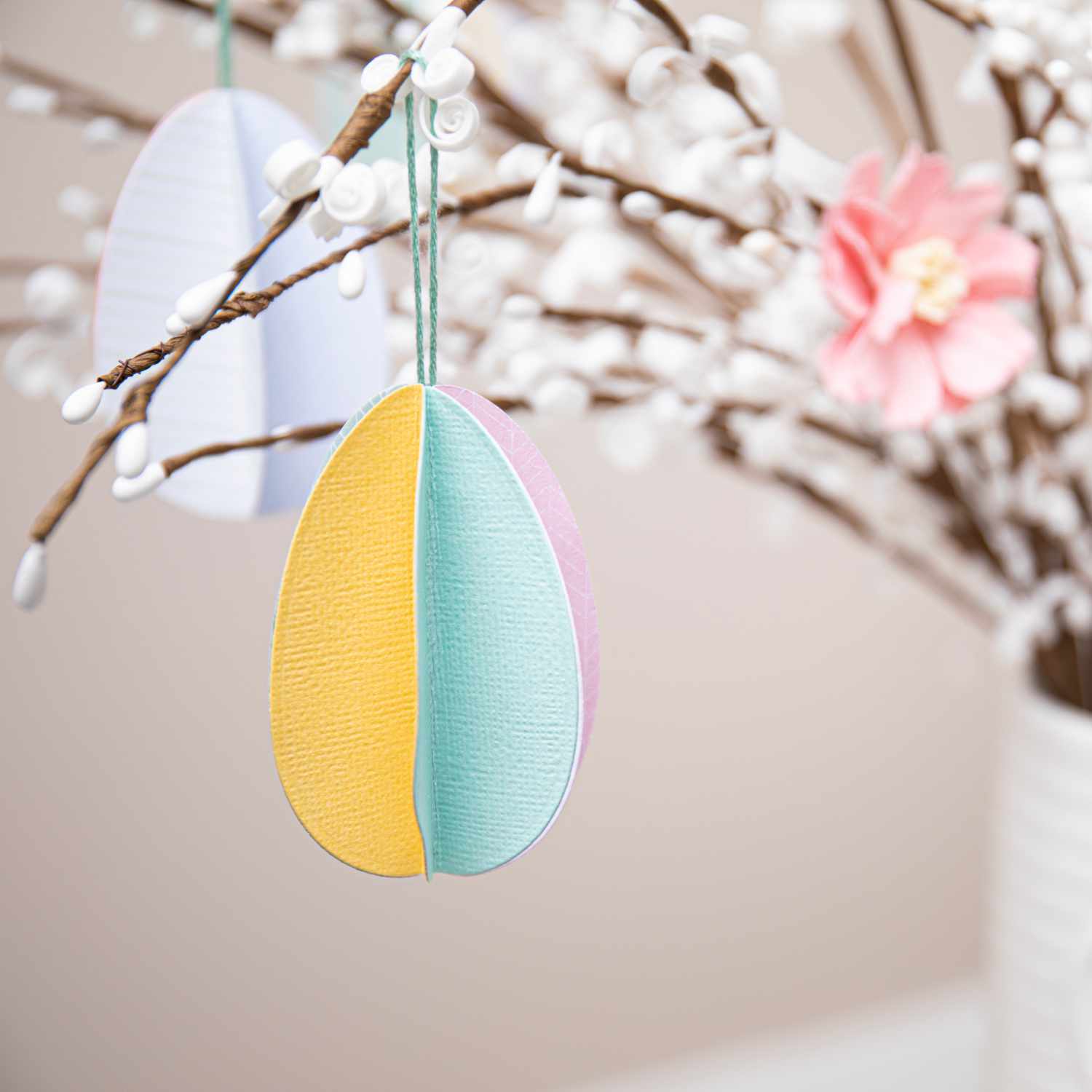 Thinlits Die Set Basic Easter Shapes: Bunte Ostereier-Dekoration an einem blühenden Zweig.