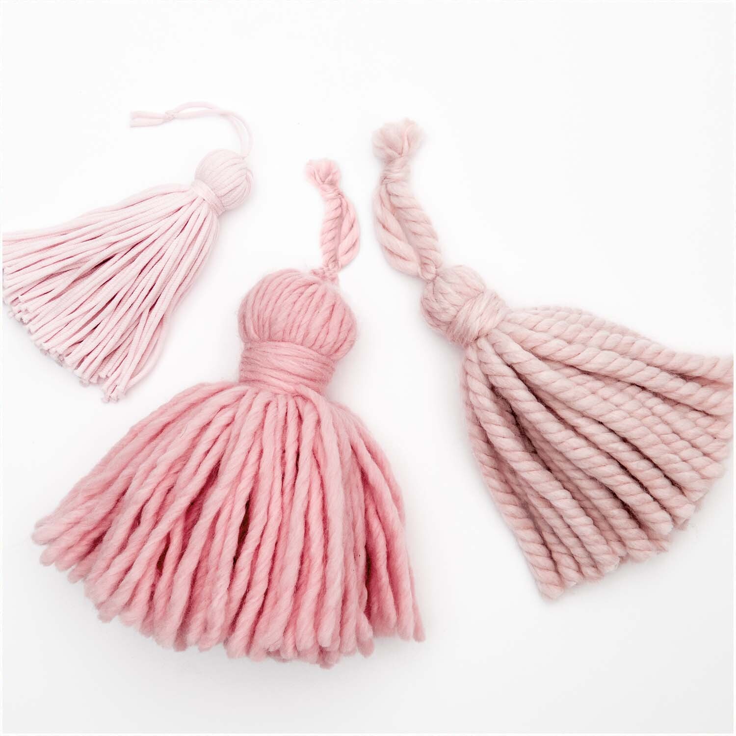 Tassel Maker Set: Drei rosa Quasten in verschiedenen Größen, ideal für kreative Bastelprojekte.