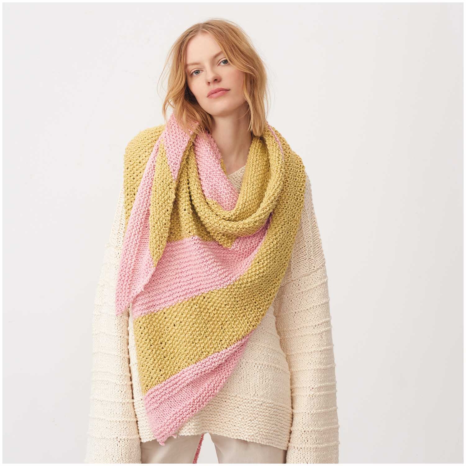 Creative So Cool + So Soft Cotton chunky: Frau trägt gestrickten Schal in Rosa und Gelb von Rico Design, ideal für kühle Tage.