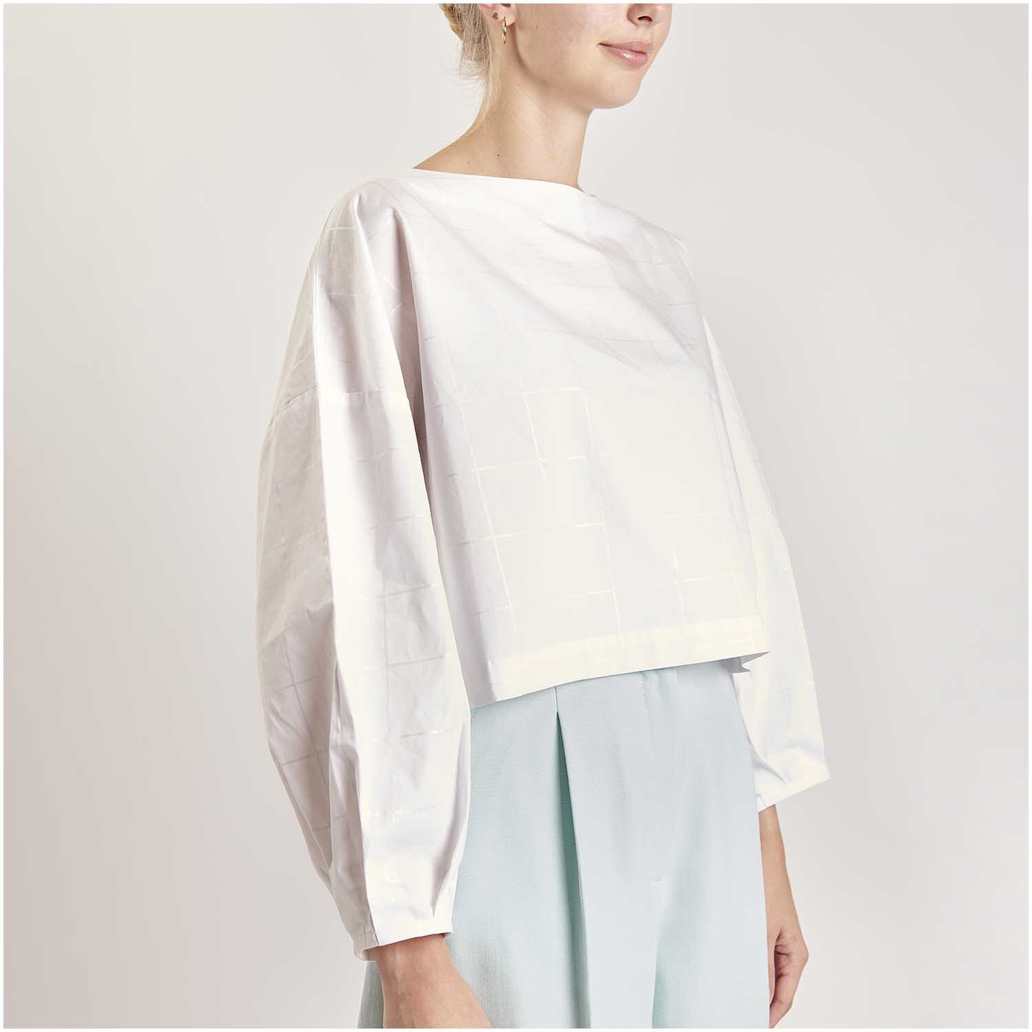 Stoffabschnitt Baumwoll-Popelin Holografisch Kariert von Rico Design, zeigt ein elegantes Oberteil in sanften Pastelltönen.